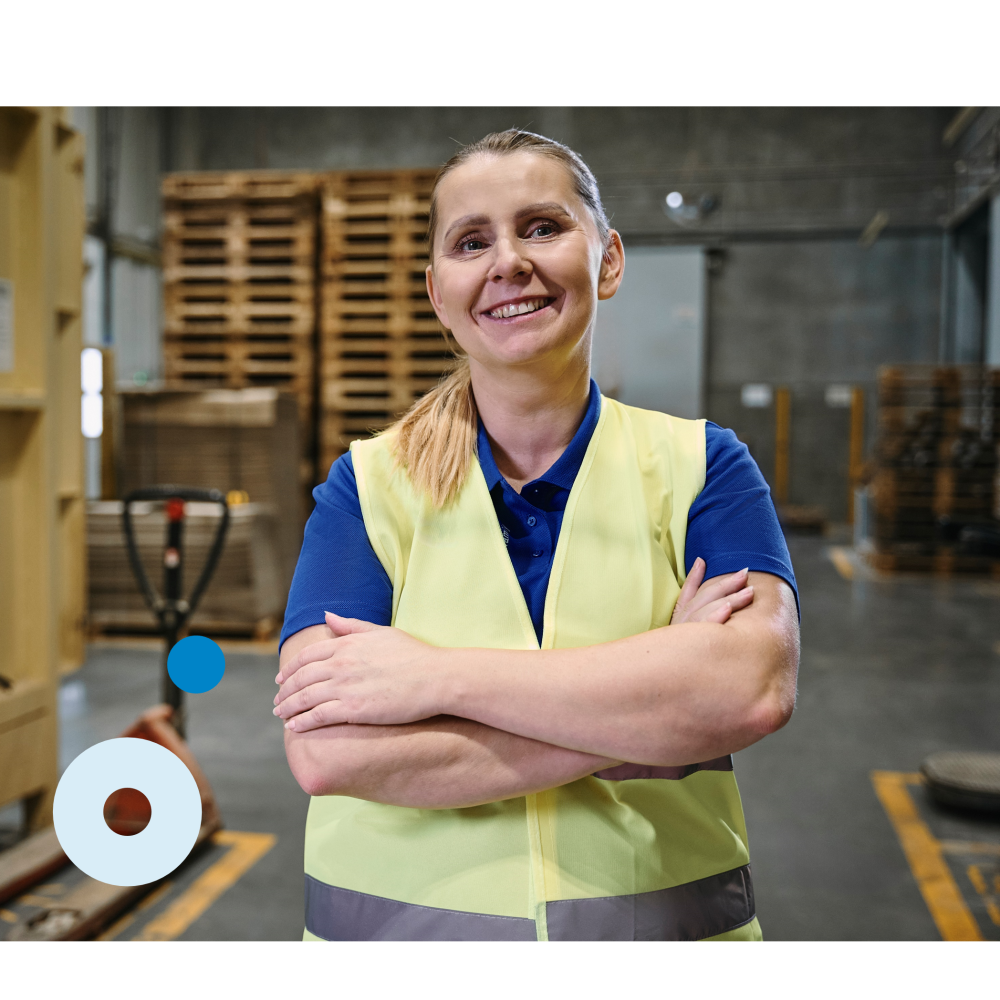 A woman standing in the factory, smiling into the camera